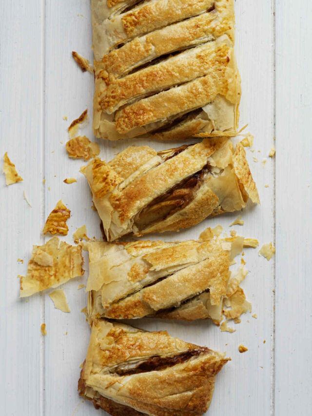 Apple strudel made with phyllo dough, partially cut into individual portions.