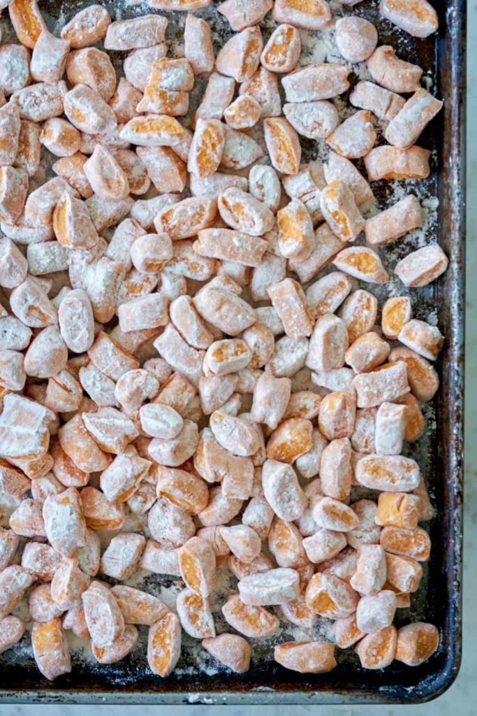 Raw sweet potato gnocchi on a baking sheet.