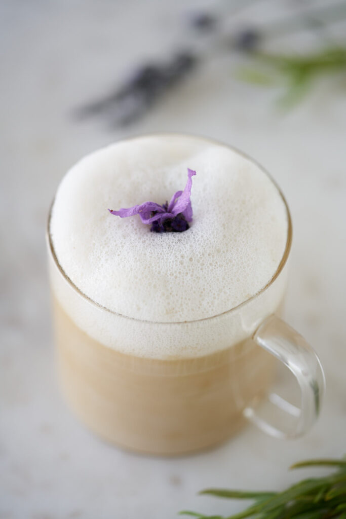 Top view of a tea latte with foam and lavender.