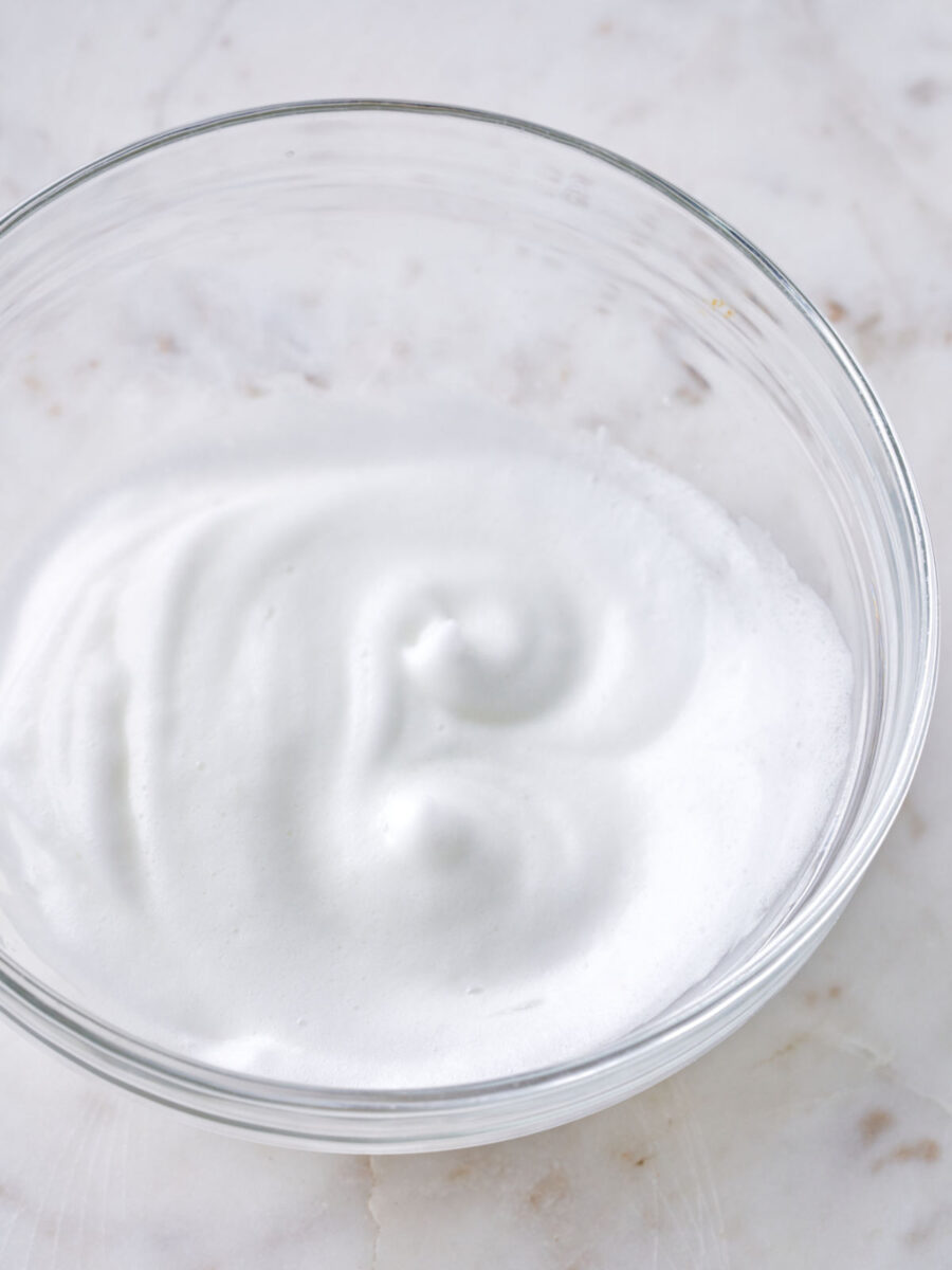 Whipped egg whites in a glass bowl.