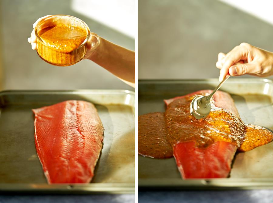 Pouring marinade over salmon and spreading it with a spoon.