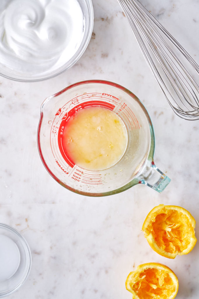 Orange and coconut milk mixed in a measuring cup.