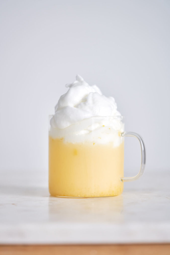 Whipped orange floof on top of an orange creamsicle drink.