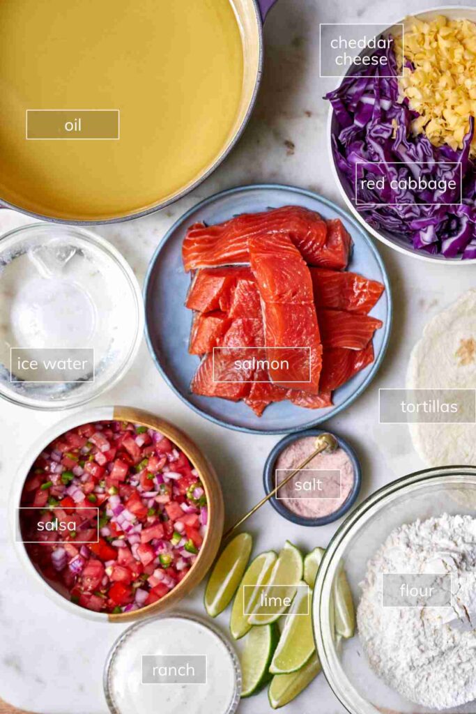 Ingredients for fried salmon tacos including oil, cheese, cabbage, water, salsa, salmon, tortillas, salt, lime, flour, and ranch.