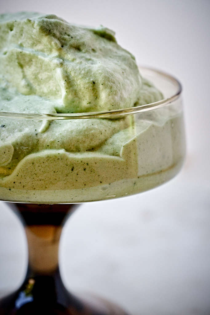 Close up of green tea mousse in a pedestal glass.