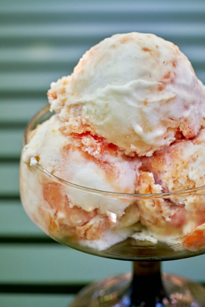 Close up of three scoops of nectarine semifreddo in a pedestal glass.