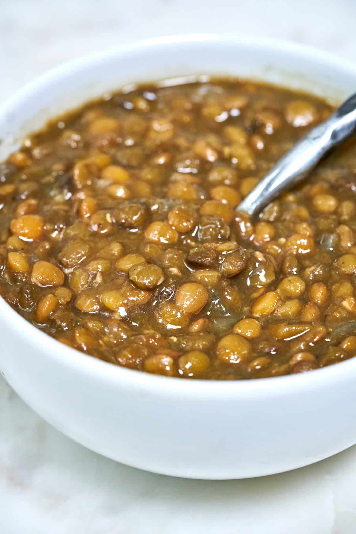 Bowl of lentils with a spoon.