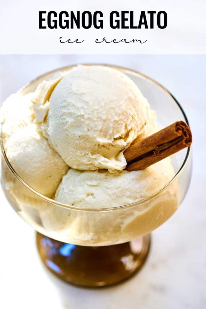 Scoops of ice cream in a glass with a cinnamon stick.