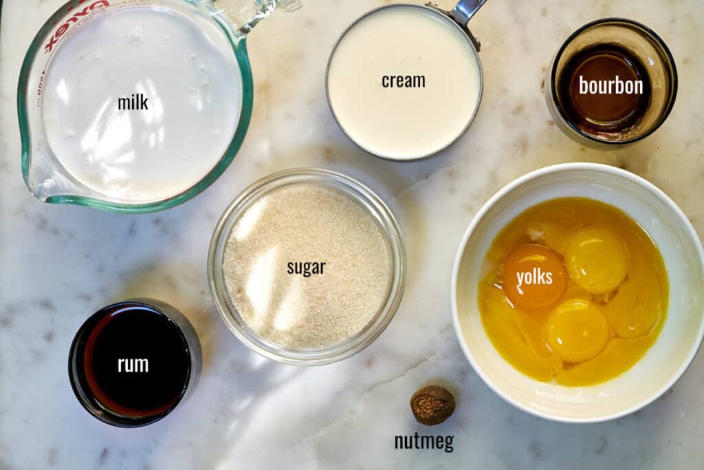 Labeled ingredients for eggnog ice cream including milk, cream, yolks, and nutmeg.