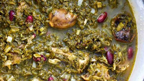 Green stew in a white pot.