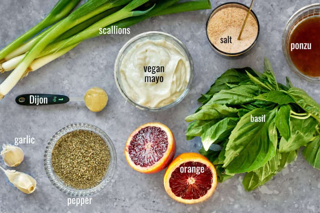 Ingredients for salad dressing on a grey table.