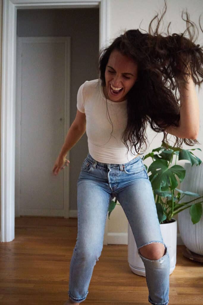 Woman dancing in a t-shirt and jeans.