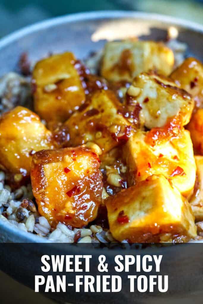 Tofu cubes covered in sticky sauce over rice.