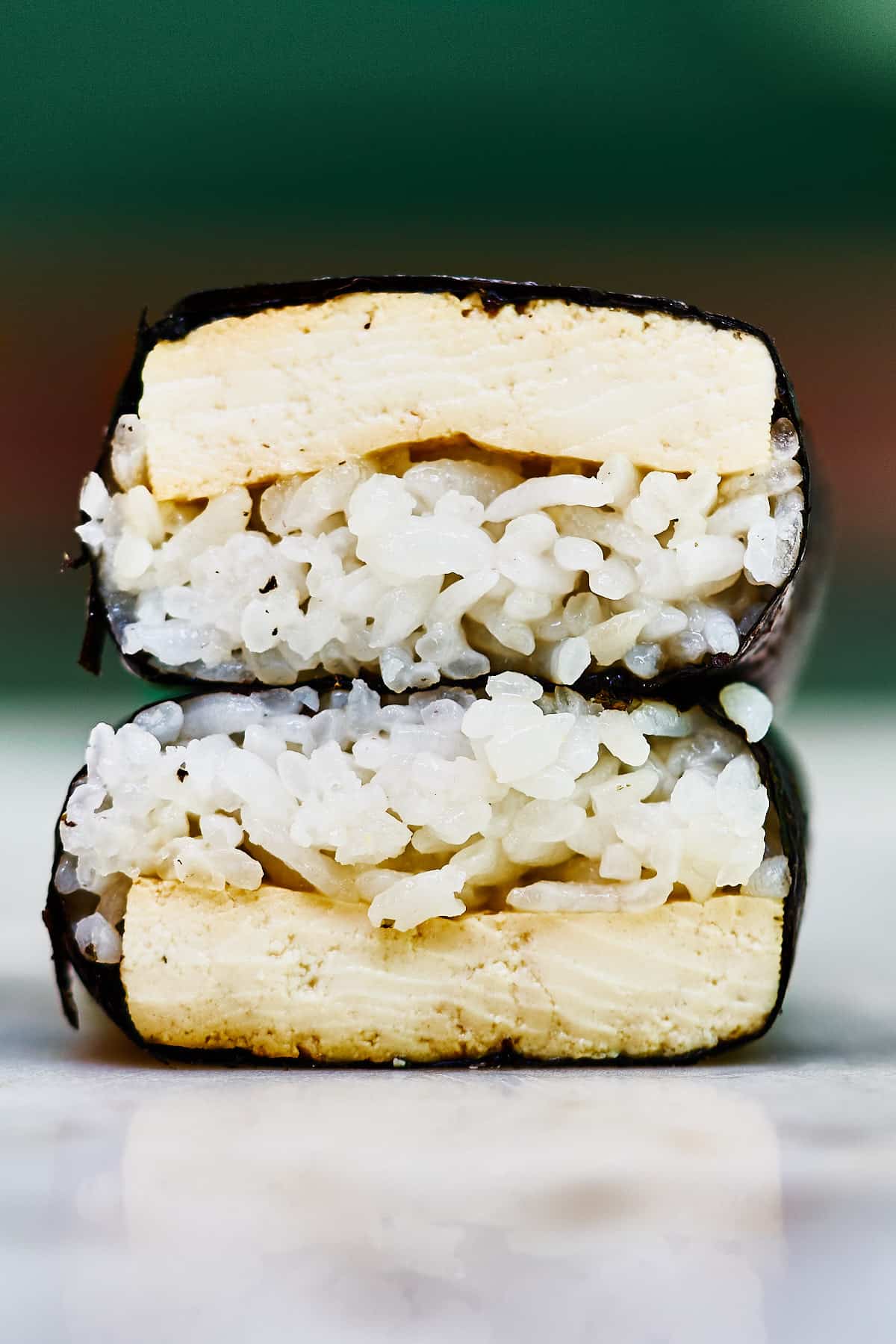 Two tofu musubi stacked on top of each other.