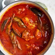 Top view of cooked eggplant stew with chicken in red sauce.