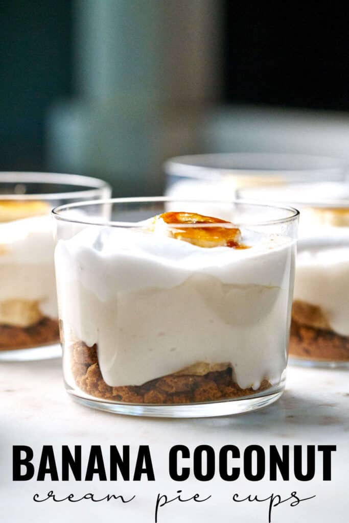 Close up of banana cream pie cup topped with a bruleed banana slice in front of more cups with title text.