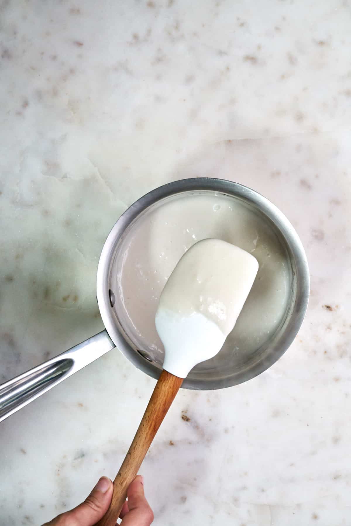 Texture of pudding on a wooden spatula.