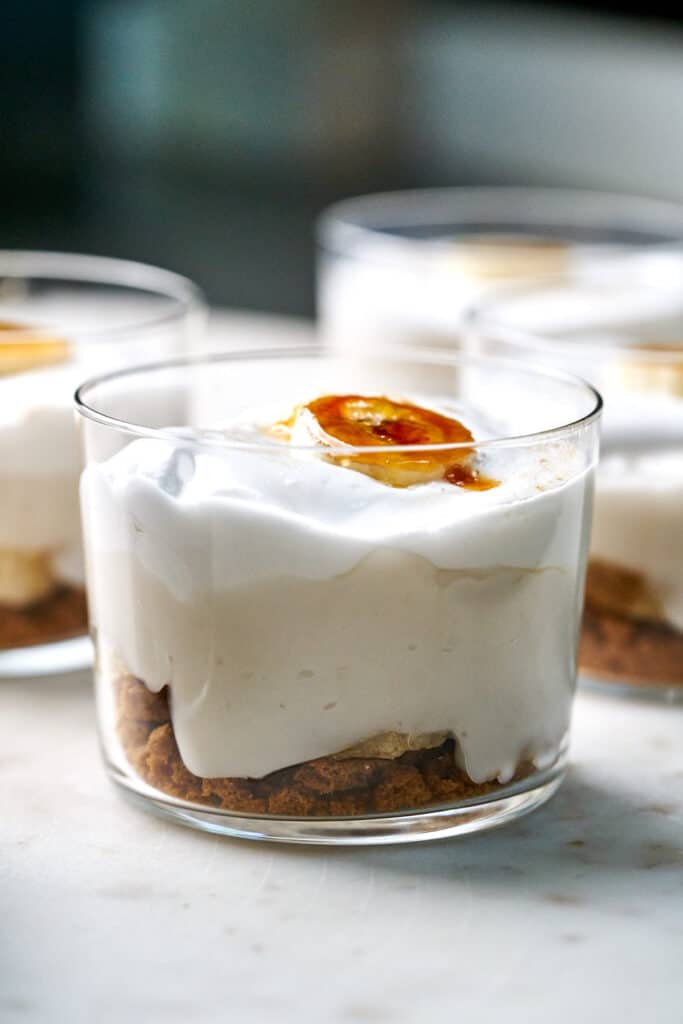 Close up of banana cream pie cup topped with a bruleed banana slice.