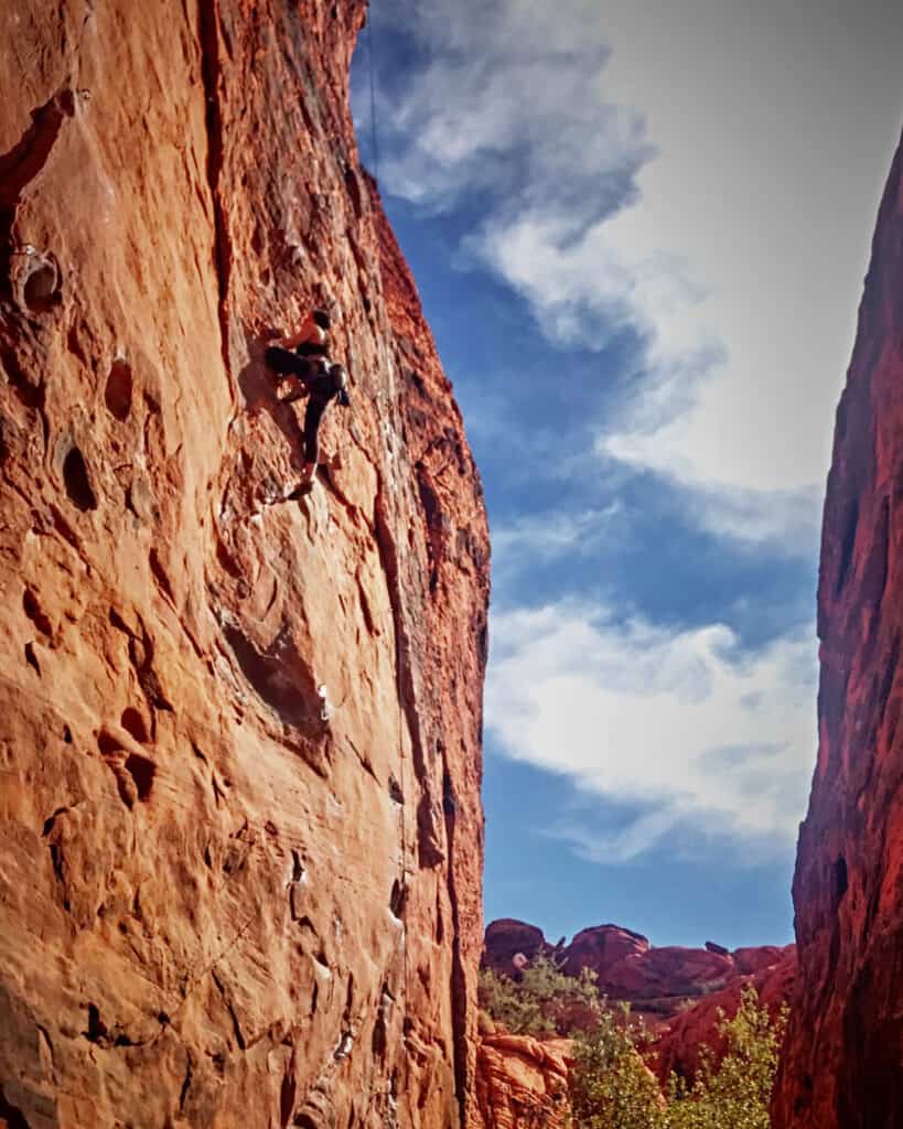 Woman climbing in red rock canyon.