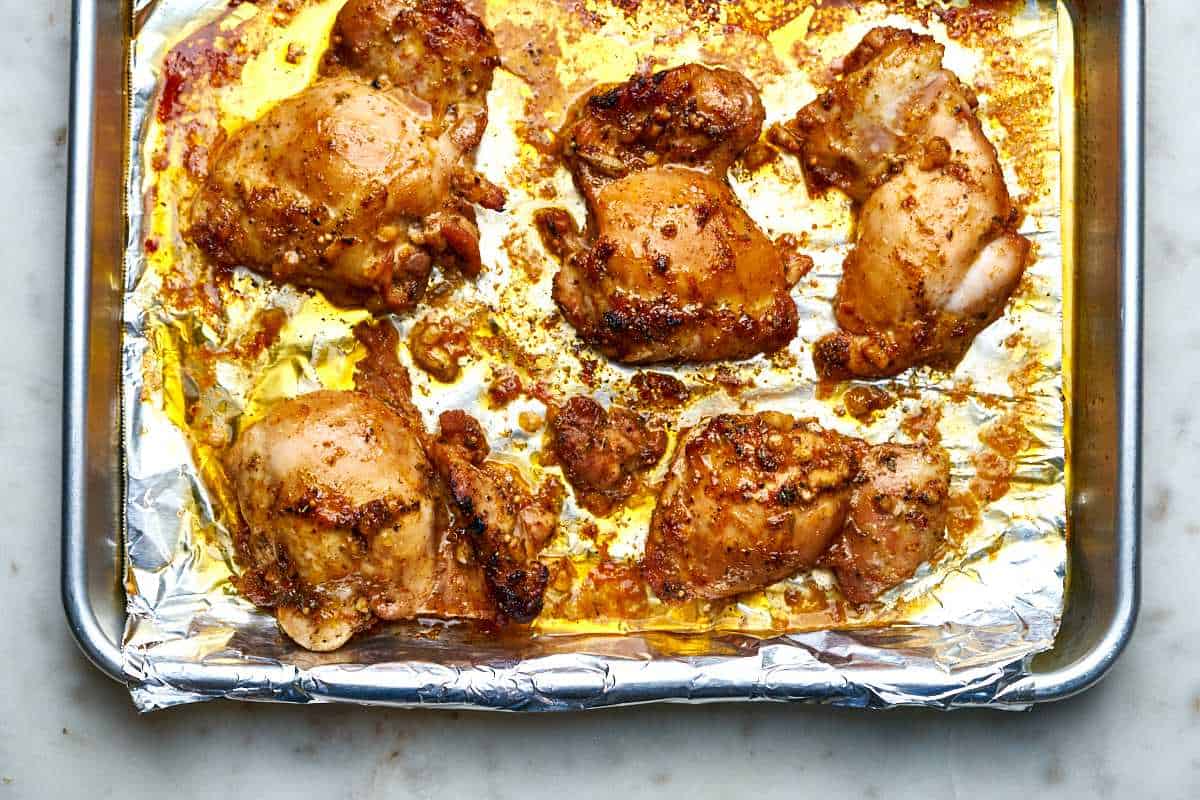 Chicken thighs on a baking sheet.
