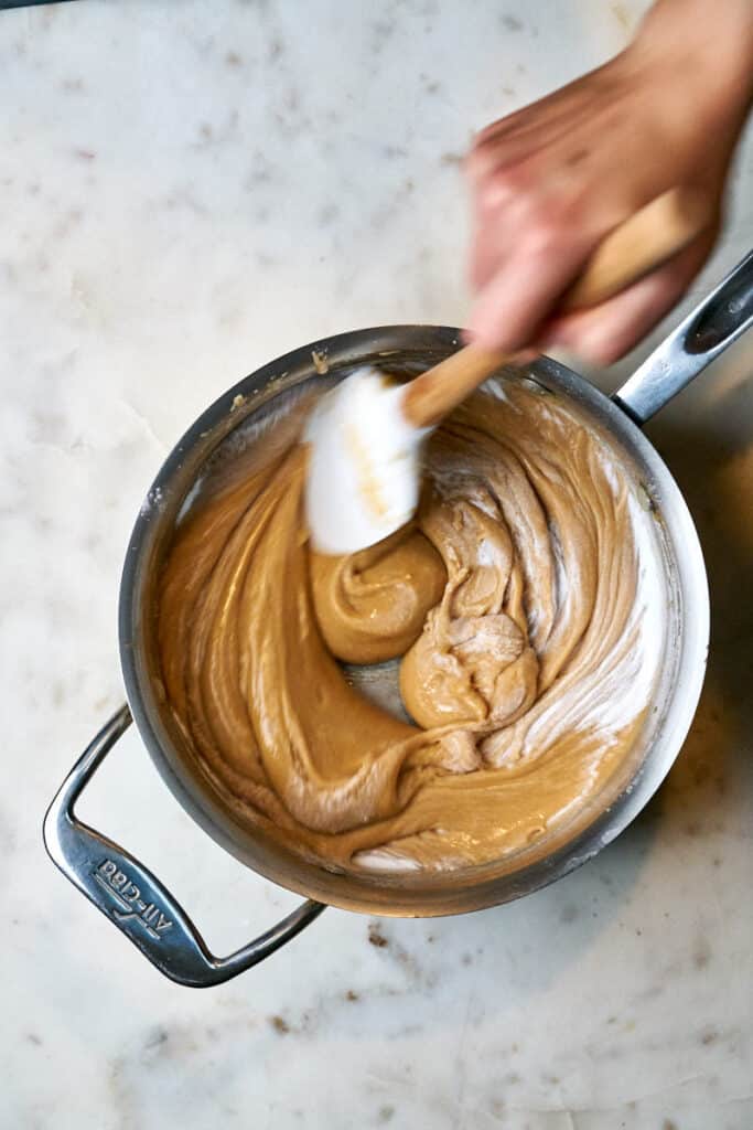 Mixing baking soda into toffee.