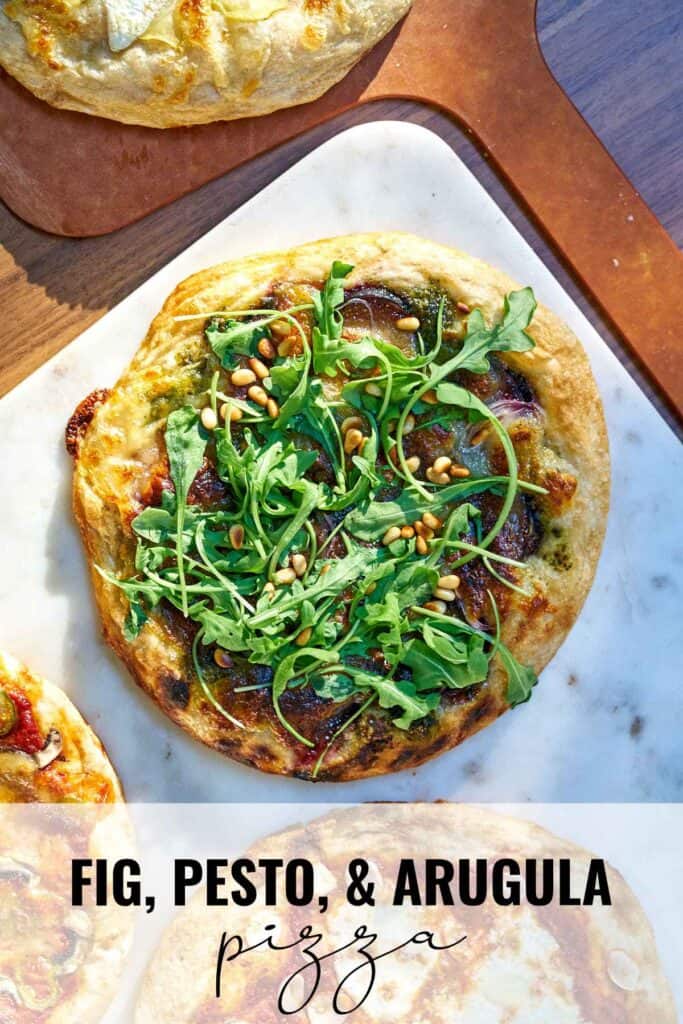 Pizza topped with arugula on white marble next to more pizza with title text.