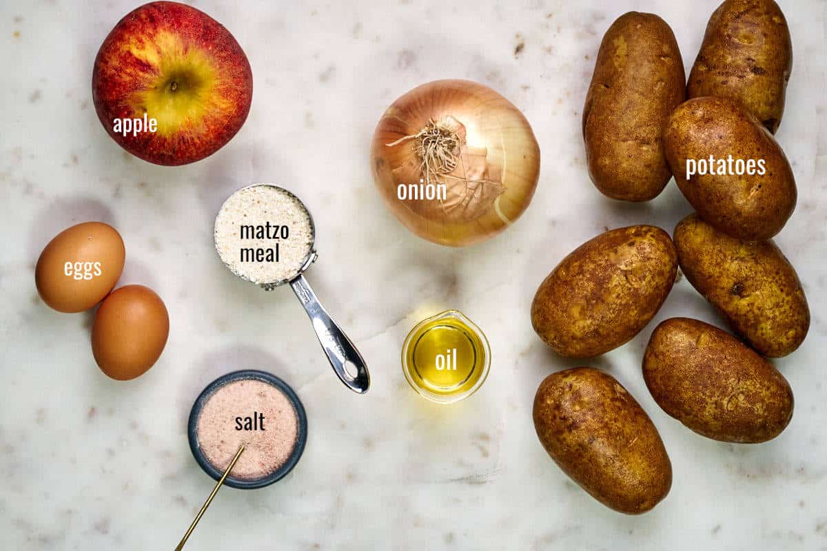 Ingredients for latkes including potatoes, onion, apple, eggs, matzo meal, oil, and salt.