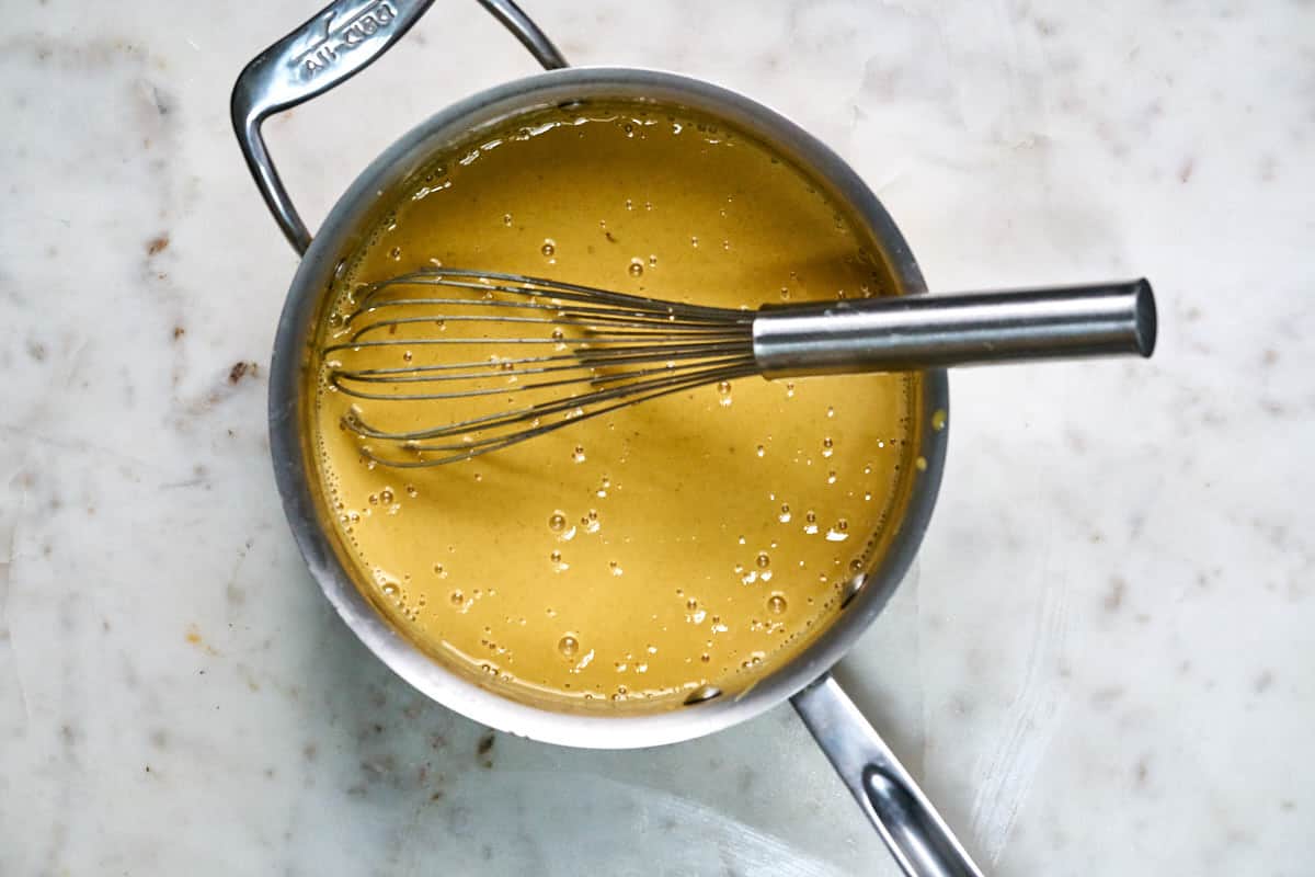 Yellow filling whisked in a saucepan.