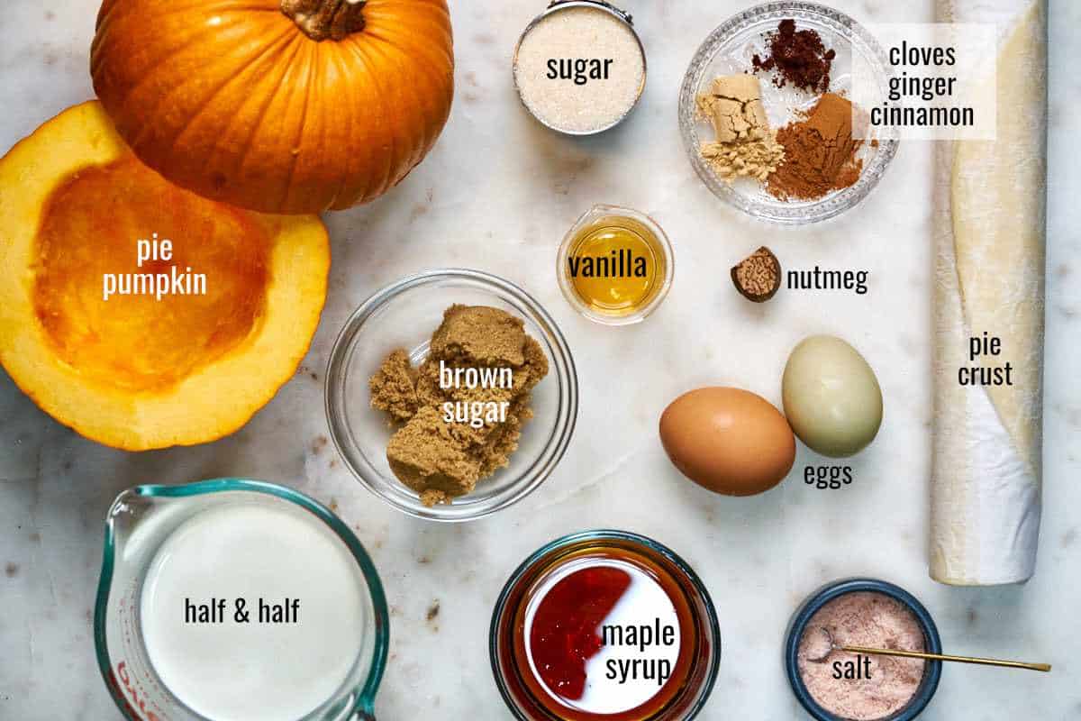 Top view of ingredients for pumpkin pie including pumpkin, half and half, sugar, and pie crust.