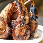 Rack of lamb standing upright on a plate.