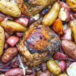 Cooked chicken and potatoes on a sheet pan.