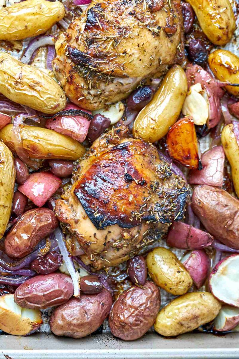 Cooked chicken and potatoes on a sheet pan.