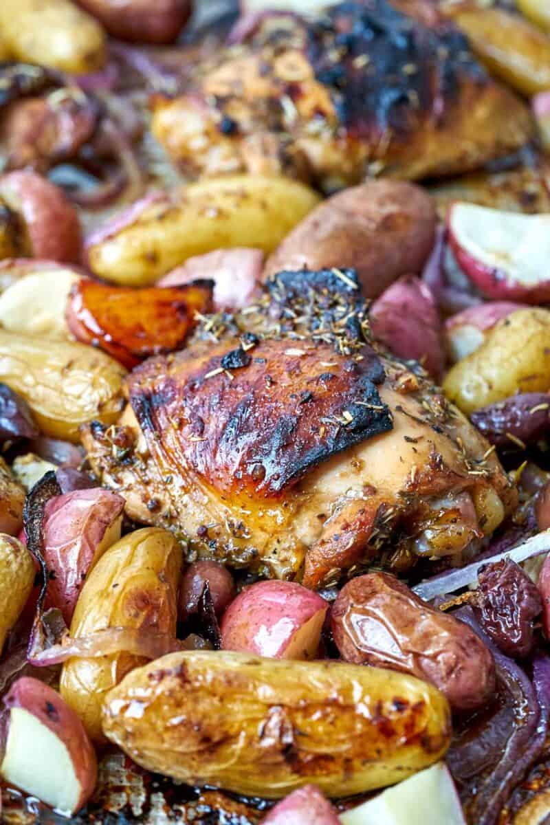 Cooked chicken and potatoes on a sheet pan.