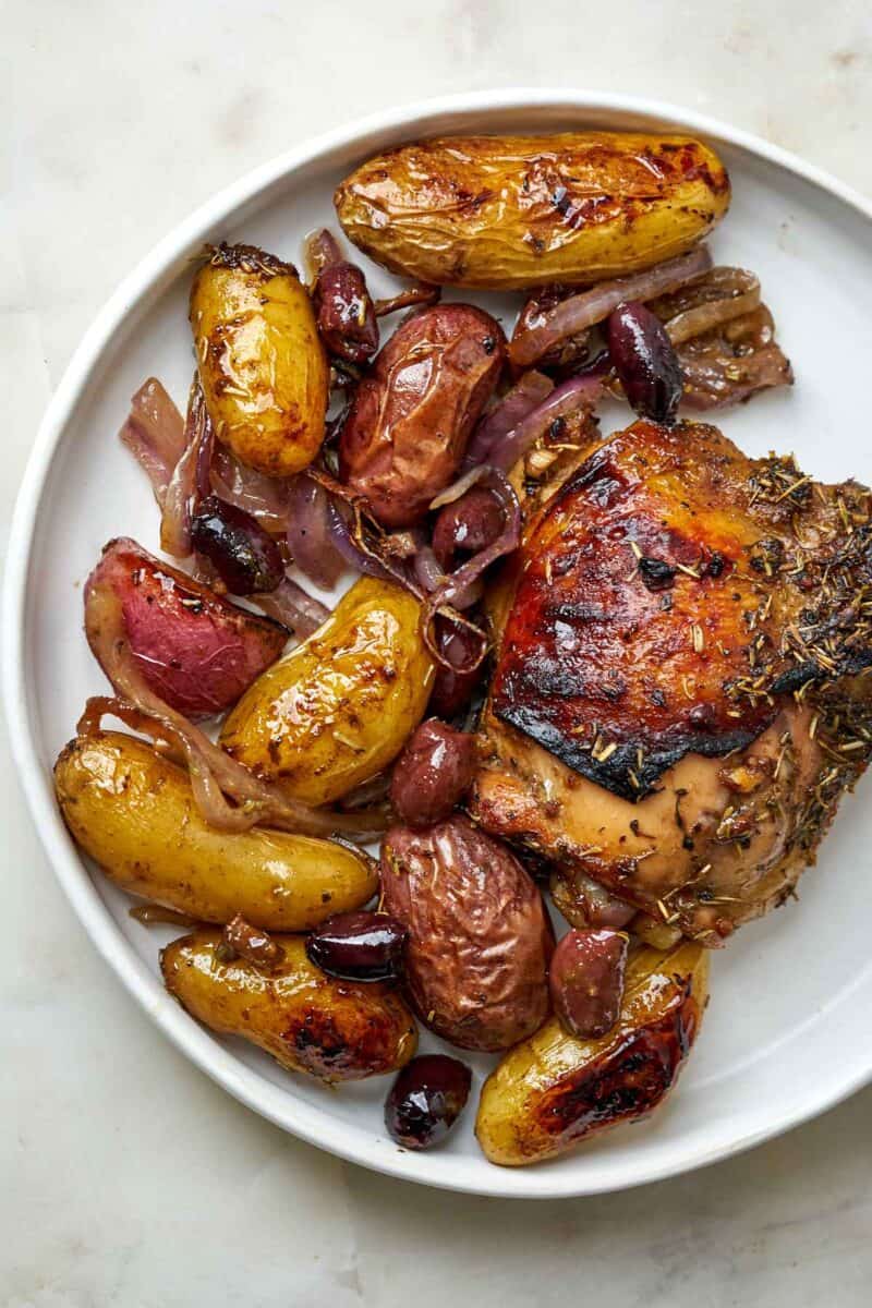 Cooked chicken and potatoes on a plate.