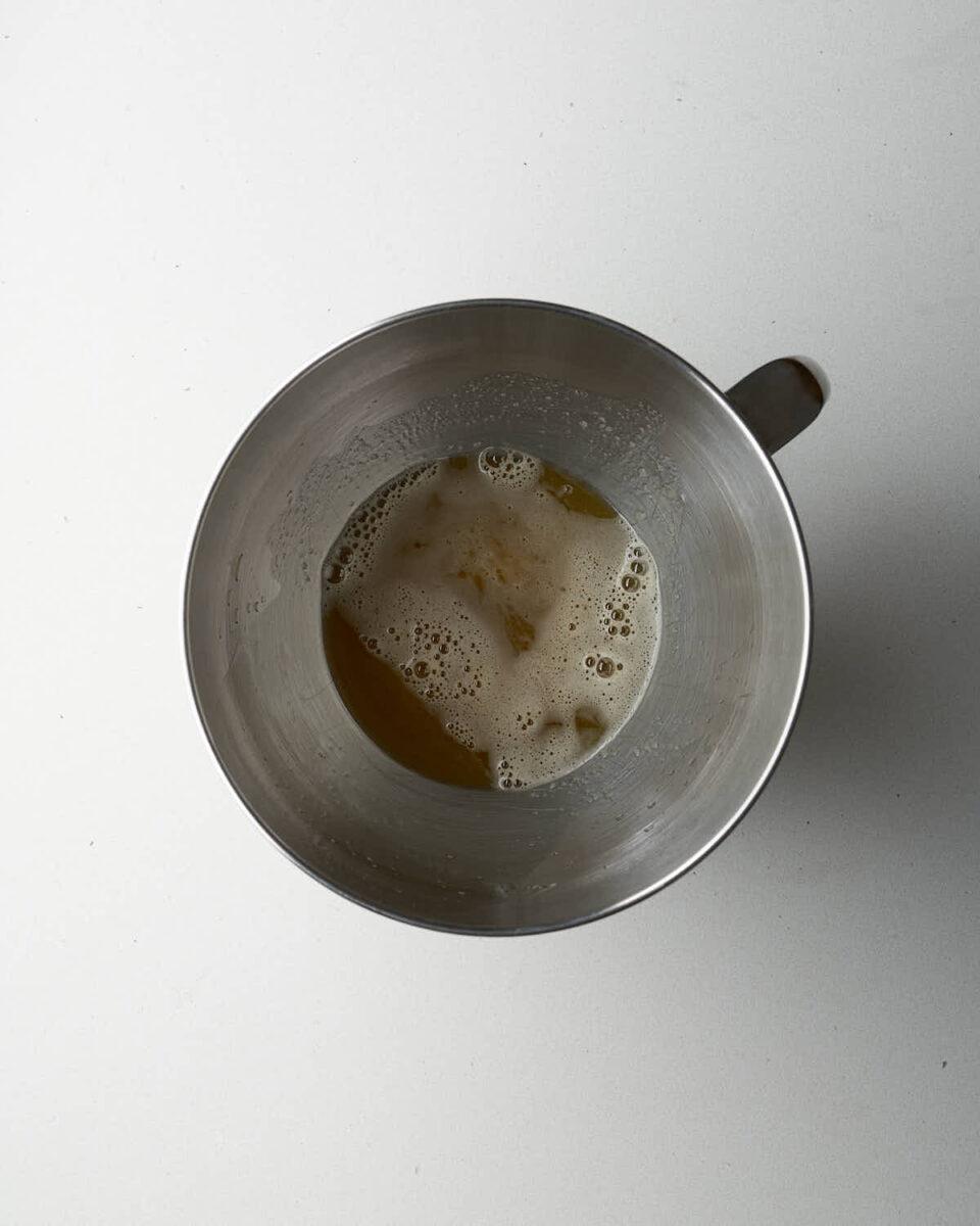 A metal mixing bowl containing melted ghee.