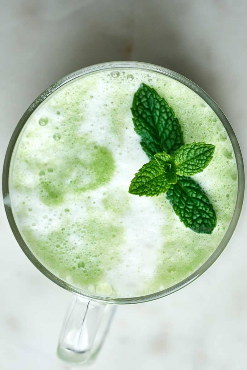 Green latte with a fresh herbs on top.