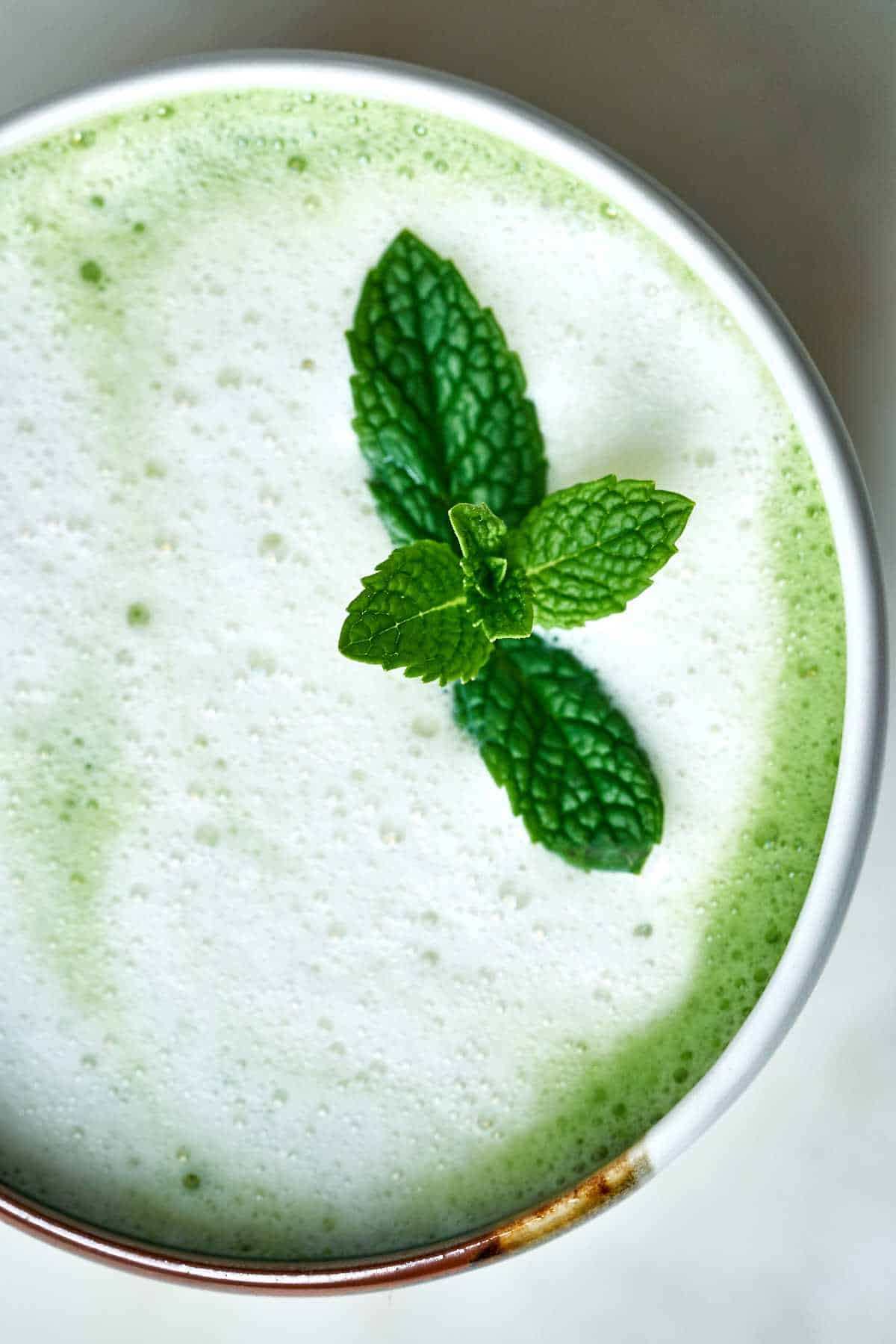 Close up of mint on a green tea latte.