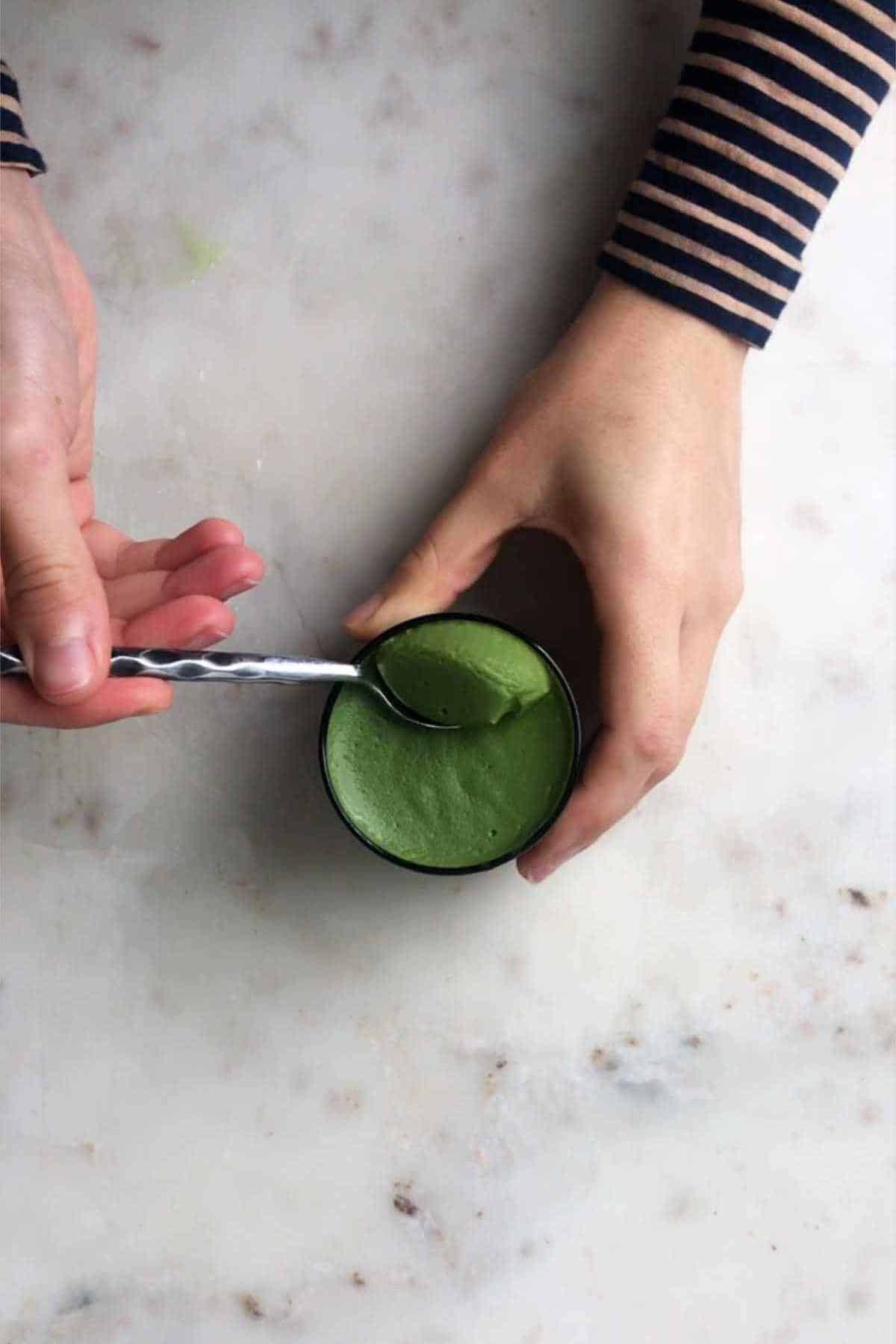 Scooping matcha pudding with a spoon.