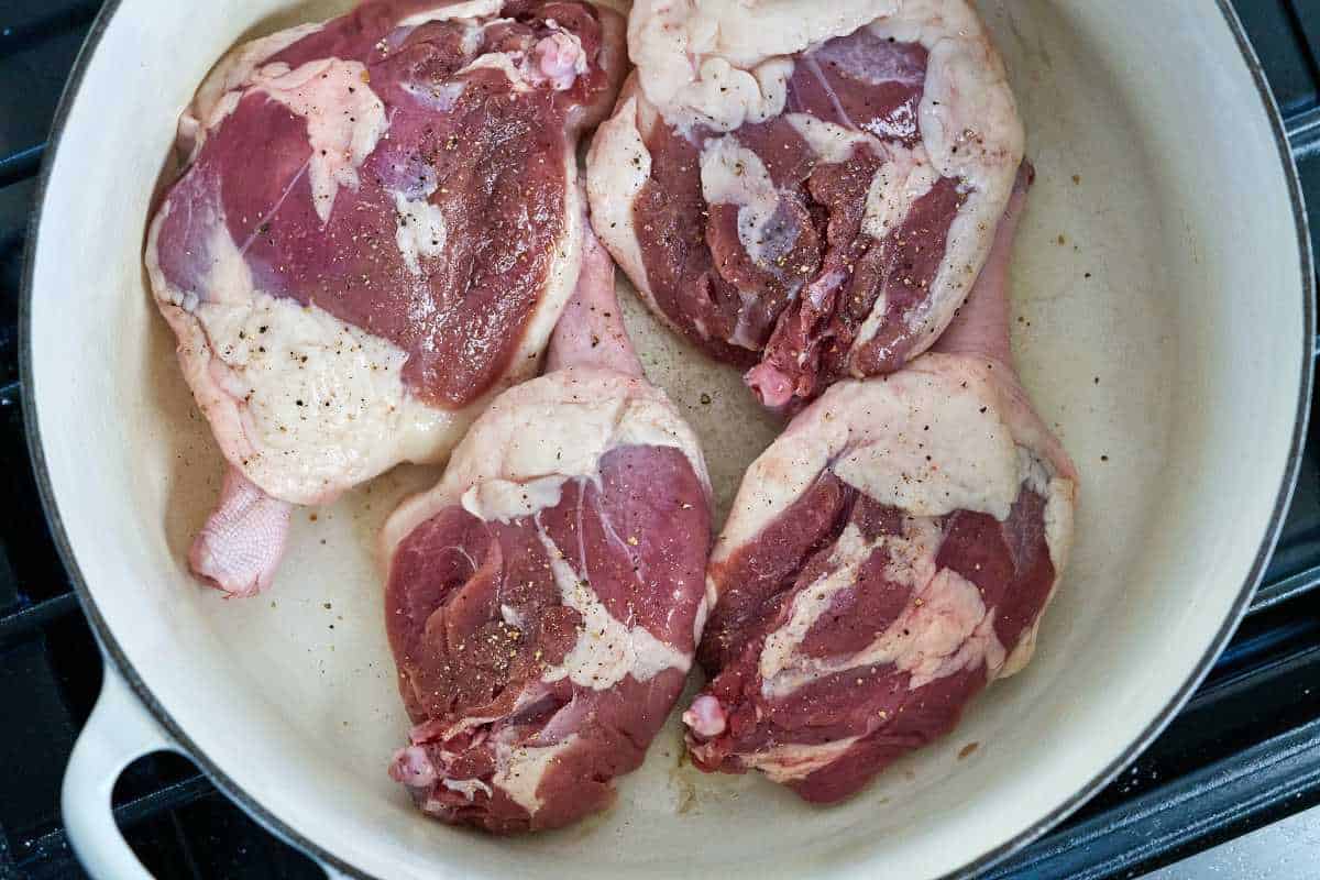 Raw duck legs in a pot.