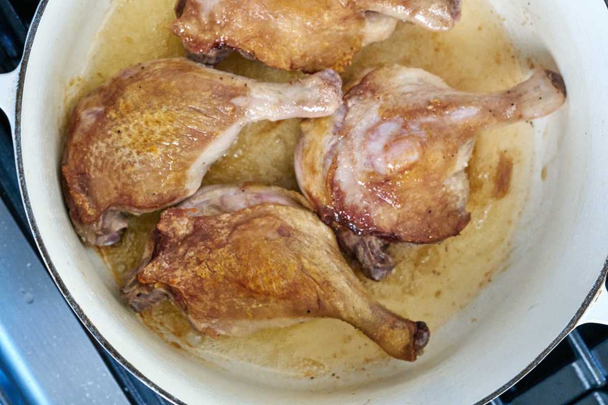 Duck legs cooking in a pot.