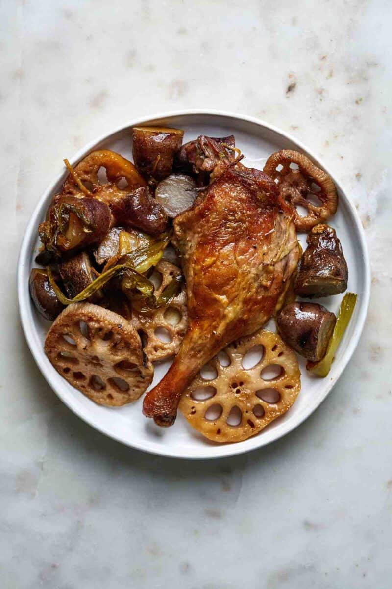 Duck leg dinner on a plate.