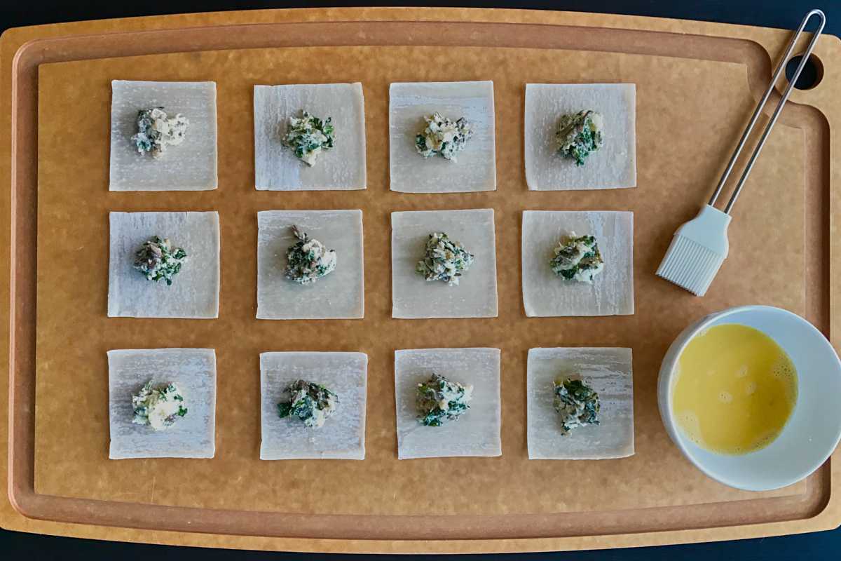 Unsealed ravioli on a baking sheet.