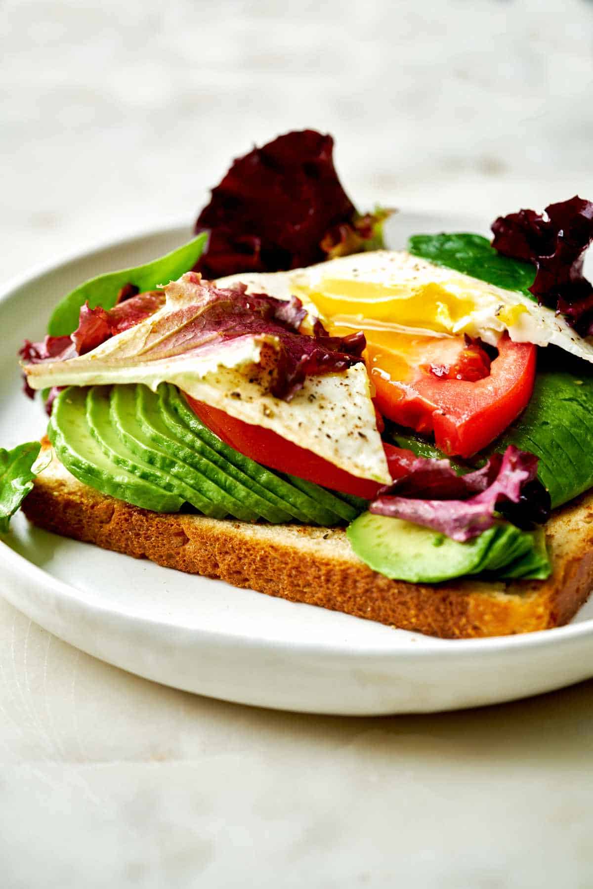 Toast with avocado, eggs, and lettuce.