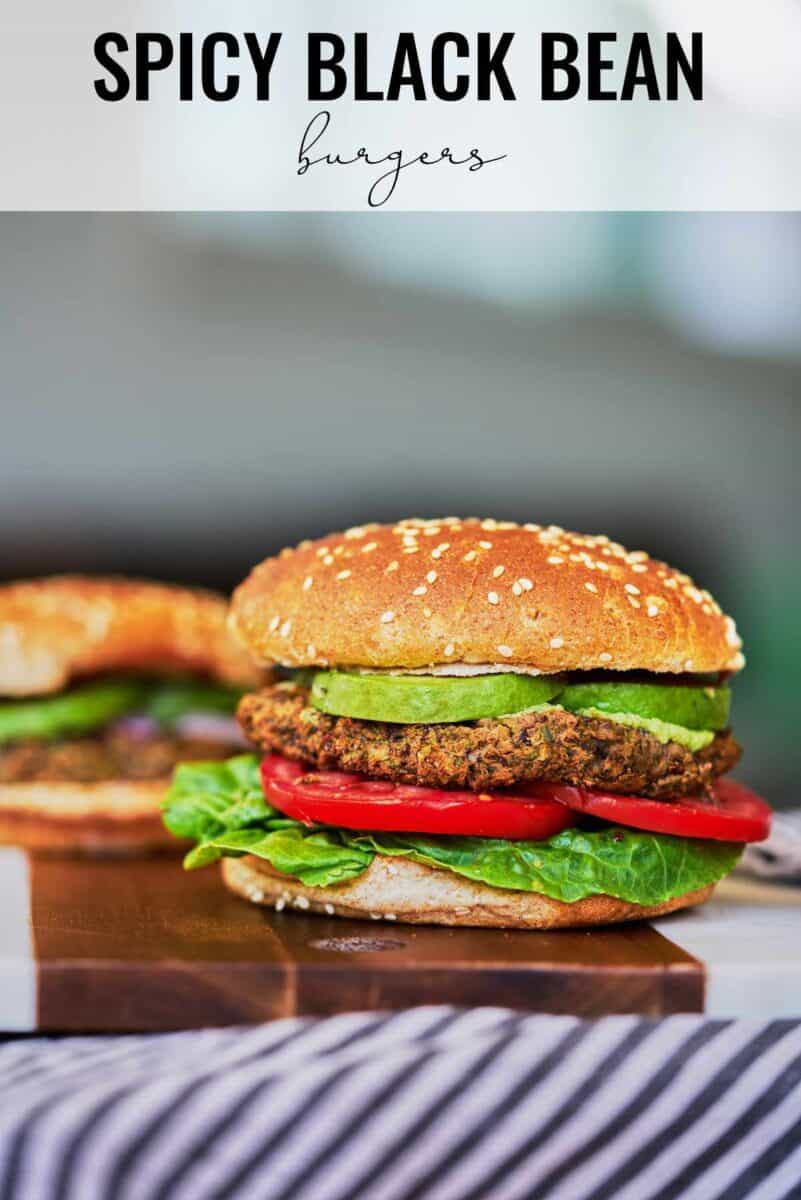 Two burgers on a cutting board.