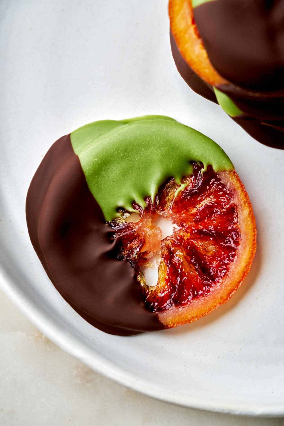 Orange slices dipped in chocolate and green chocolate.