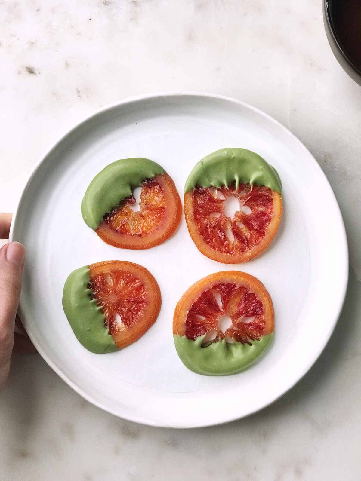 Orange slices dipped in green tea chocolate.