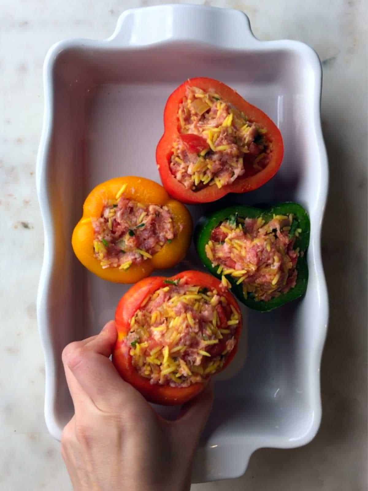 Stuffing peppers with rice filling.
