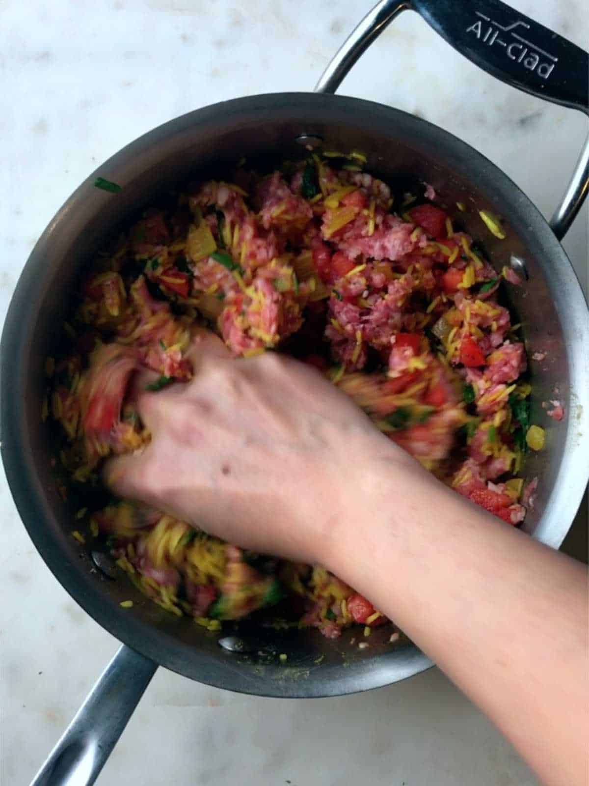 Mixing meat and rice mixture in a pot.