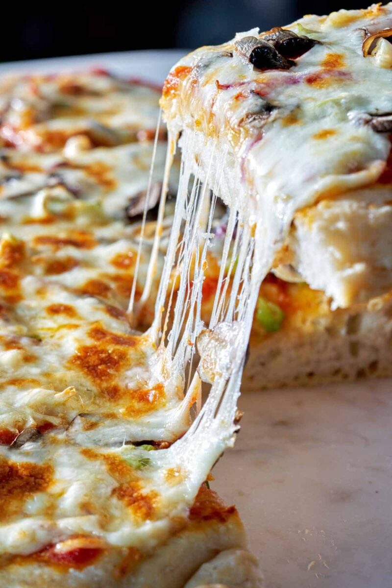Cheese pull on pizza.