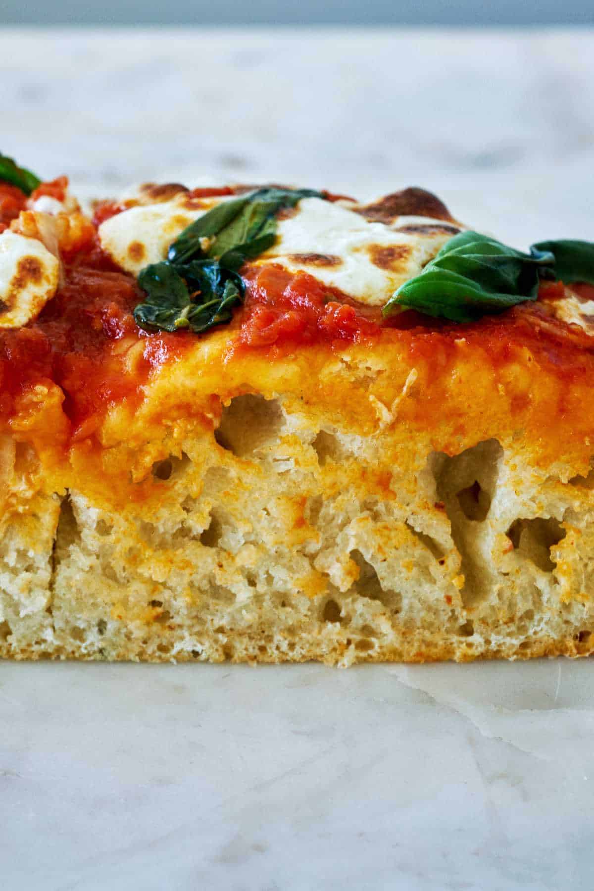 Slice of thick focaccia pizza.